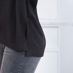 Polerón Marina negro, con detalles en los laterales, combinado con jeans grises.