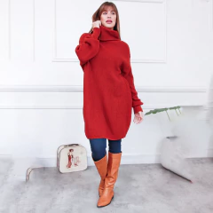 Modelo luciendo un polerón rojo de cuello alto, combinado con jeans y botas de cuero marrón.
