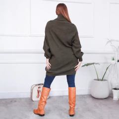 Modelo de espaldas usando un polerón verde oscuro, combinado con pantalones ajustados y botas largas de color naranja.