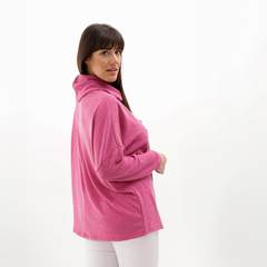 Poncho polera de color rosa, con cuello y corte amplio, usado por una mujer de perfil.