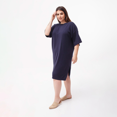 Túnica Prisma de color azul marino, con mangas cortas y un diseño cómodo, vista lateral de una modelo que lleva sandalias.