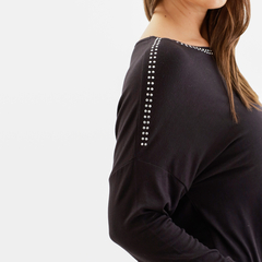 Remera negra de mujer con detalles de strass en el hombro, vista lateral.