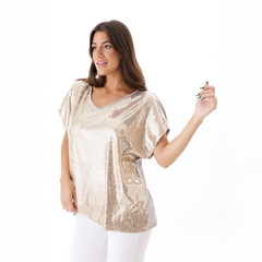 Remera brillante en color dorado con escote en V, modelo de mujer que sonríe y posa con la mano levantada.