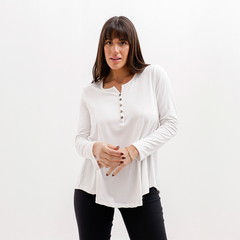 Remera Darise de color blanco con botones en el escote, presentada por una modelo con cabello largo y lacio.