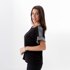 Remera Domi negra con detalles brillantes en las mangas, utilizada por una mujer que sonríe.