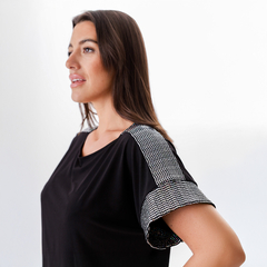 Remera Domi negra con detalles brillantes en las mangas, vista lateral de mujer