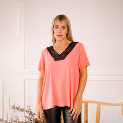 Remera de color coral con detalles de encaje negro, modelo de manga corta.