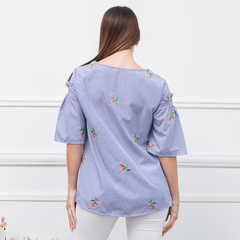 Remera Kaia de color azul con rayas y bordados de flores, vista posterior.