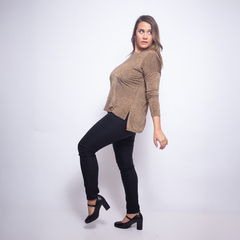 Mujer con remera manga larga color marrón claro y pantalón negro posando de perfil