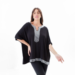 Remera Matilde negra con detalle plateado en el escote y la parte inferior, modelo posando.