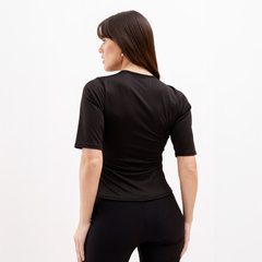 Camiseta negra ajustada vista desde atrás, con mangas cortas y detalles en la tela.