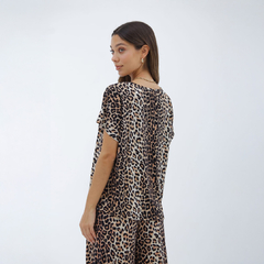 Mujer de espaldas vistiendo una remera con estampado de tigre en tonos beige y negro.