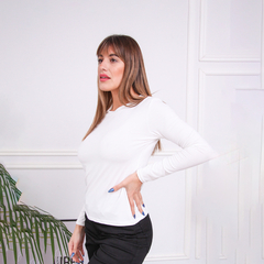 Remera blanca de manga larga modelo Vicku, presentada por una modelo en un ambiente elegante.