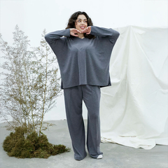 Modelo usando un remertón gris Vica, posando con una expresión alegre en un entorno minimalista.
