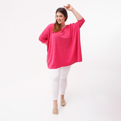 Remerón de color fucsia con detalle de broderie, modelo femenino, luciendo una sonrisa y posando de manera alegre.