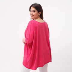 Remerón Alma Broderie en color rosa, con diseño de bordados, mostrado desde atrás por una modelo sonriente.