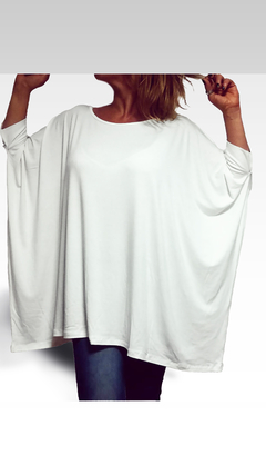 Remerón blanco de manga larga, con corte holgado y cuello redondo, usado por una mujer.