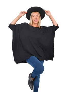 Remerón Alma Largo negro, de manga larga, con una modelo usando un sombrero y jeans, posando de forma elegante.