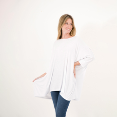 Remerón blanco de manga corta, con diseño amplio y suelto, usado por una mujer sonriente.