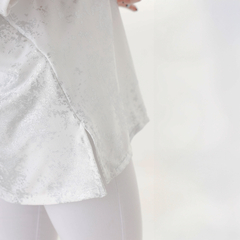Remerón Bim MC en color blanco con detalles brillantes y cortes laterales, combinado con legging blanco.