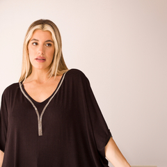 Remerón Chloe MC en color negro con detalles brillantes en el escote, modelo con cabello rubio y fondo claro.