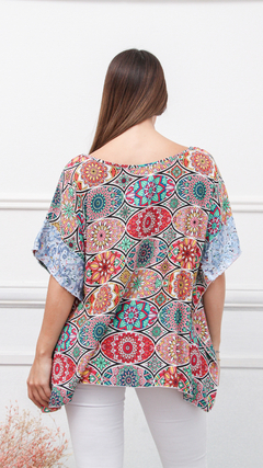 Remerón Coco con estampado colorido, visto desde atrás, con mangas amplias y un diseño floral vibrante.