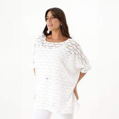 Remerón de crochet blanco con diseño de calados, modelo femenino mirando hacia un lado.