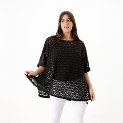 Remerón crochet negro con diseño de calado, modelado por una mujer que lo sostiene ligeramente desde el borde.