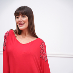 Remerón Janis de color rojo con detalles en las mangas, modelo posando sonriente.