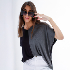 Modelo con remerón Juno de dos tonos, negro y gris, posando con gafas de sol grandes.