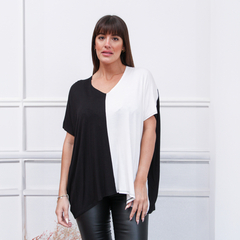 Remerón Juno en color negro y blanco, modelo de manga corta, con diseño asimétrico, combinado con pantalones de cuero negro.