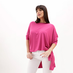 Remerón López en color rosa, con corte holgado y mangas largas, modelo de mujer posando con pantalones blancos.