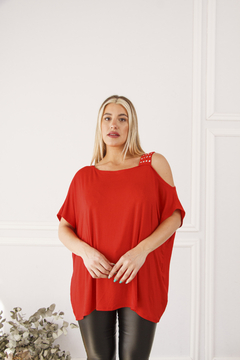 Remerón Mika de color rojo con tachas en el hombro, modelo de mujer posando con pantalones negros.