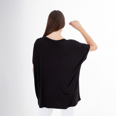 Mujer de espaldas vistiendo una camiseta negra Remeron Murano, con mangas amplias y detalles sencillos.