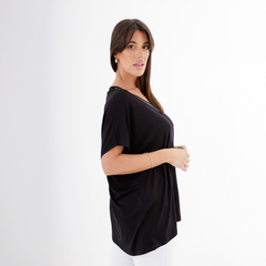 Modelo luciendo una blusa negra de la marca Remeron Murano, con detalles en el escote.