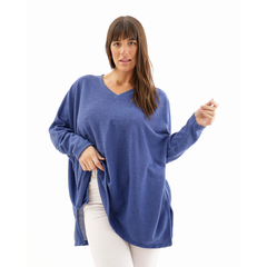 Remeron Odette de color azul, con un diseño de cuello en V y mangas largas, presentado por una modelo que sostiene una mano hacia afuera.