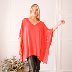 Remerón Sila color rojo, con mangas amplias y detalles en lentejuelas, modelado por una mujer con fondo neutro.