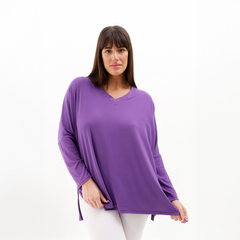 Modelo vistiendo una blusa púrpura de manga larga con escote en V.
