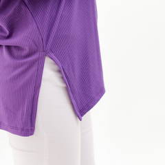 Detalle de una blusa morada con textura de rayas y corte lateral.