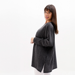 Remerón Sonia en color gris, con corte amplio y mangas largas, modelado por una mujer de pie.