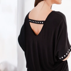 Mujer usando una blusa negra con detalle en la parte posterior.