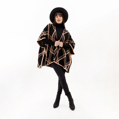 Ruana Rachele con diseño a rayas en tonos negros y beige, presentada por una modelo que lleva un sombrero negro y un atuendo de invierno.