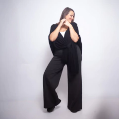 Mujer con ruana negra Batilde, posando sobre fondo blanco