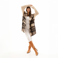 Saco Ikia de colores beige y marrón, con diseño de cuadros, usado por una modelo que viste pantalones blancos y botas marrones.