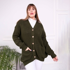 Modelo vistiendo un saco inglés de color verde oliva con botones frontales y bolsillos, sobre un fondo claro.