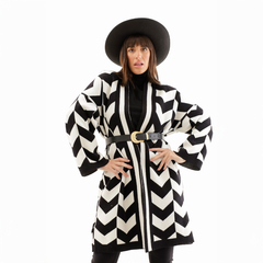 Saco Maya en blanco y negro, con diseño de zigzag, usado por una modelo que lleva un sombrero negro y un cinturón dorado.