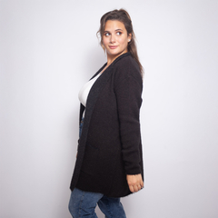 Saco Victoria negro, largo, con bolsillos, modelado por una mujer con cabello largo y castaño claro