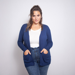 Modelo luciendo un spolverino Magnolia color azul marino, con un top blanco y jeans. El spolverino tiene bolsillos frontales.
