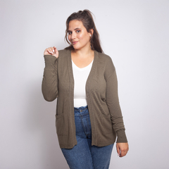 Modelo luciendo un spolverino Magnolia de color oliva, con un top blanco y jeans ajustados.