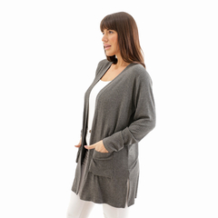 Modelo usando un spolverino gris con bolsillos, ideal para combinar con outfits casuales.